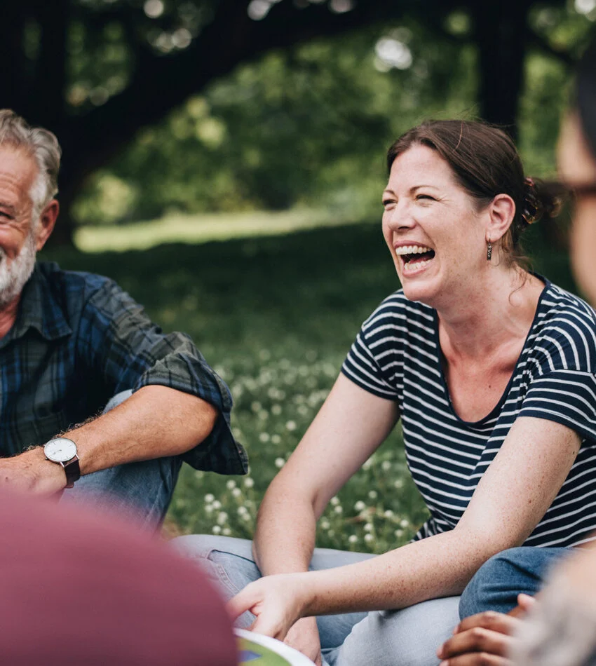 Adults laughing together in an outdoor small group