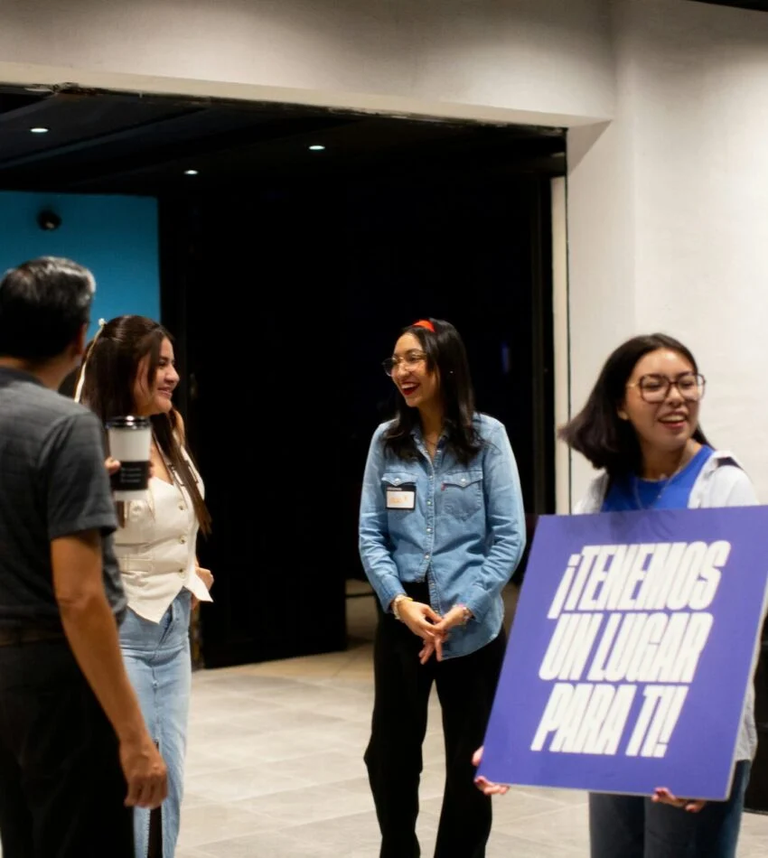Young adults welcoming guests in the church lobby