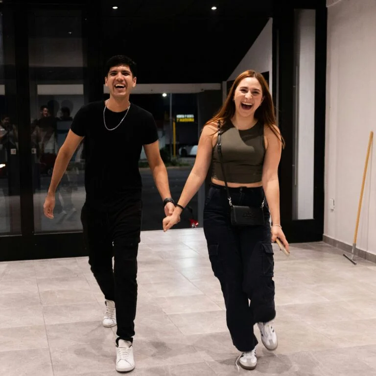 A smiling couple walking into church hand in hand