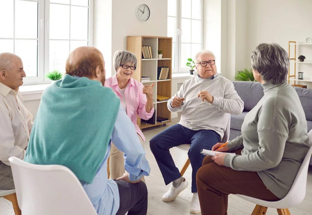 Older adults talking together in a circle of chairs