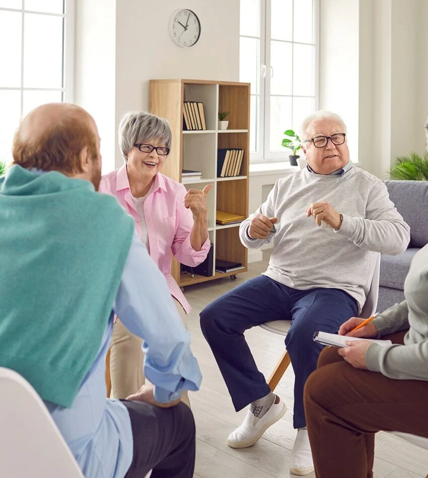 Older adults talking together in a bright living room