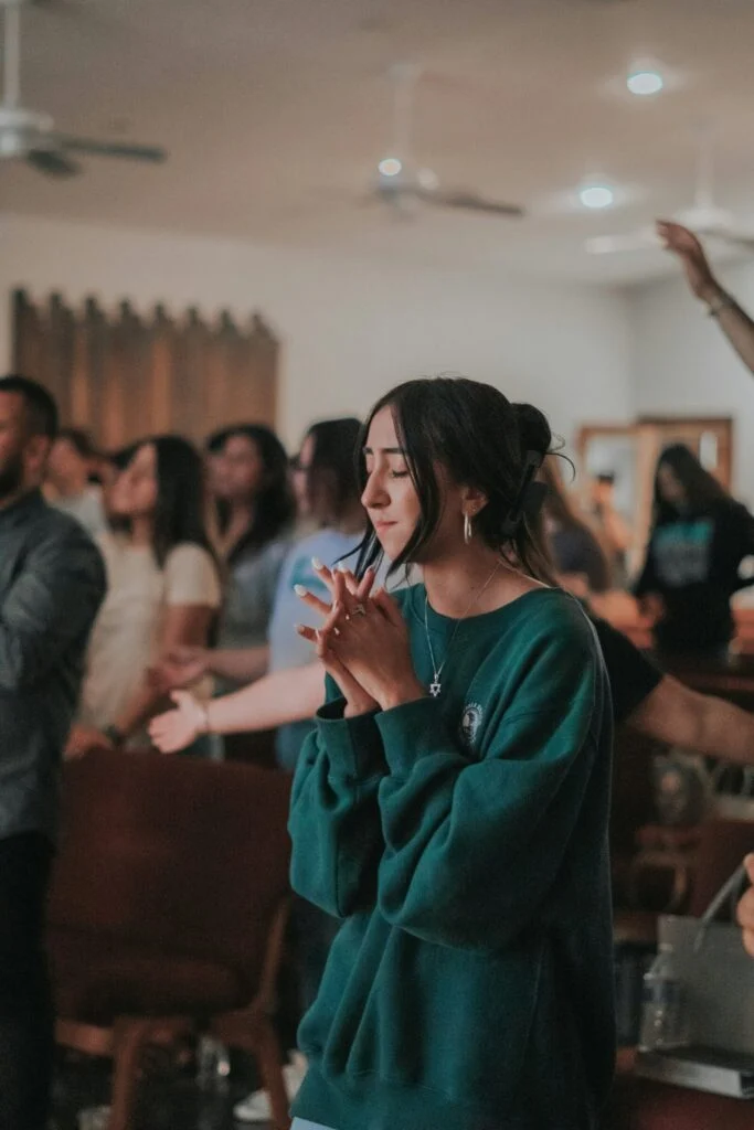 A woman clapping and worshipping during a church service